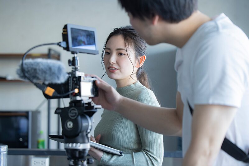 動画制作の依頼先を検討するイメージ。撮影現場でカメラ機材を確認しながら進行する様子